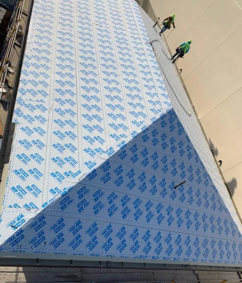 Professional roofers installing underlayment on a metal roof in Canby